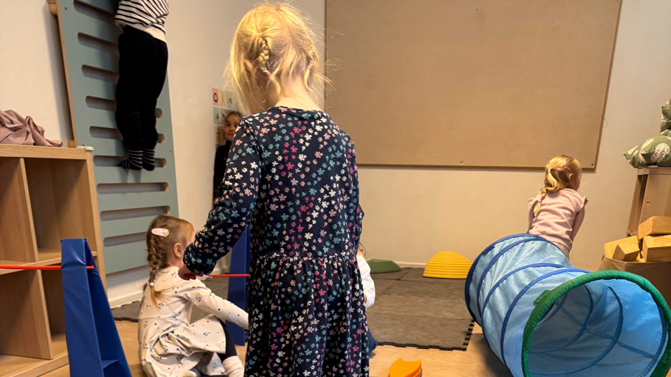Barn som gymnastiserar med redskap och lekobjekt.