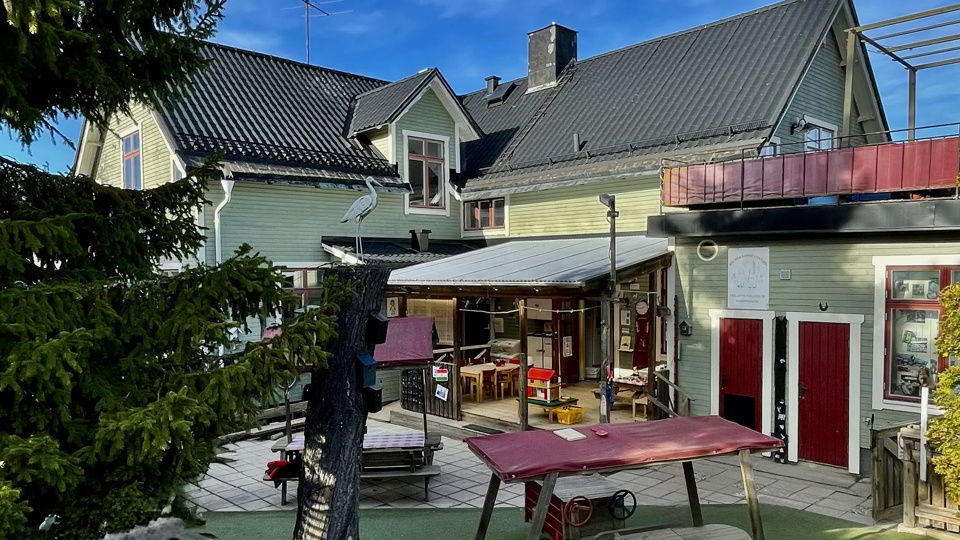 Innergård med bland annat lekredskap, sittplatser och altan med tak.