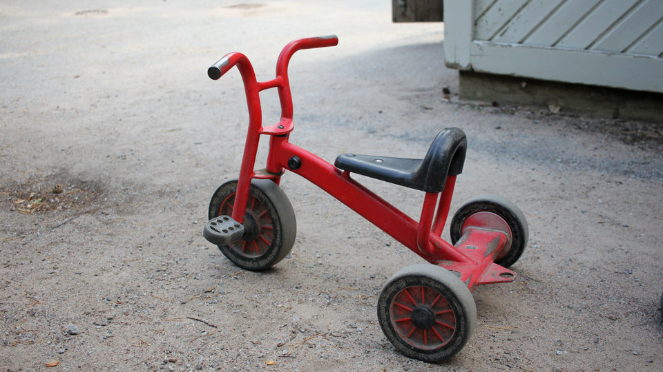 Röd cykel för små barn på en grusgång.