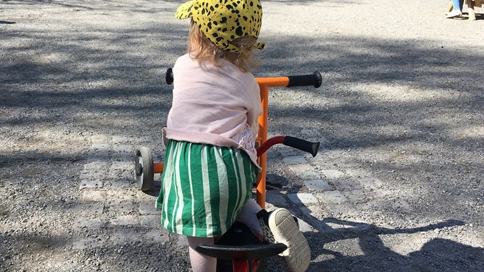 Ett yngre barn som cyklar i utomhus parken.