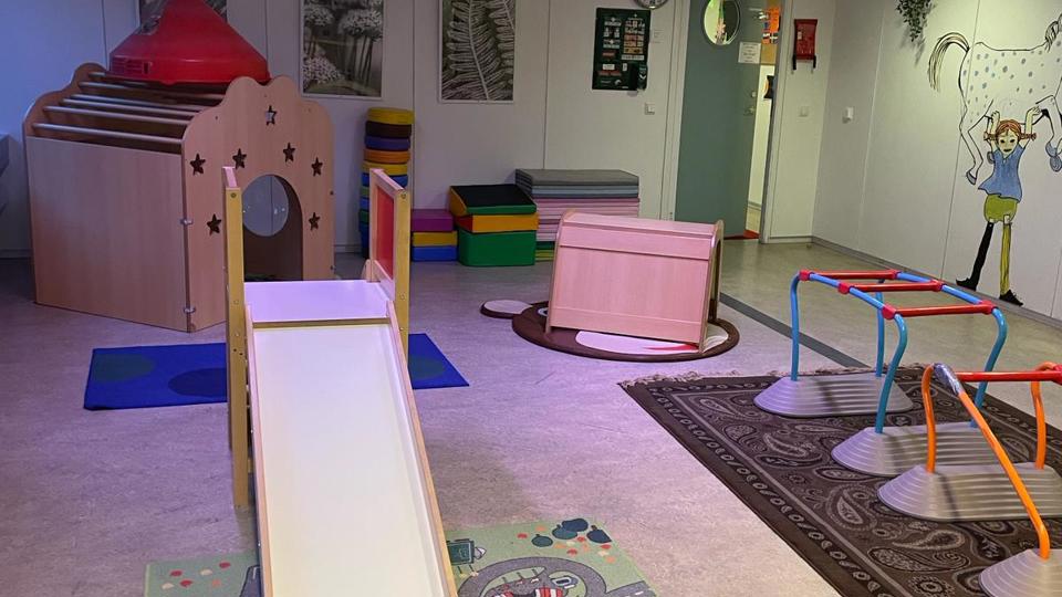 Ett rum med rutchkana och klätterställning. På golvet ligger mattor och på väggen finns en stor bild av Pippi Långstrump målad. Foto