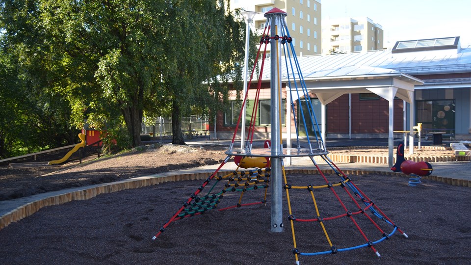 Bild på förskolans ljusa och öppna innergård som erbjuder stora ytor, lekutrustning och material för aktiva lekar.
