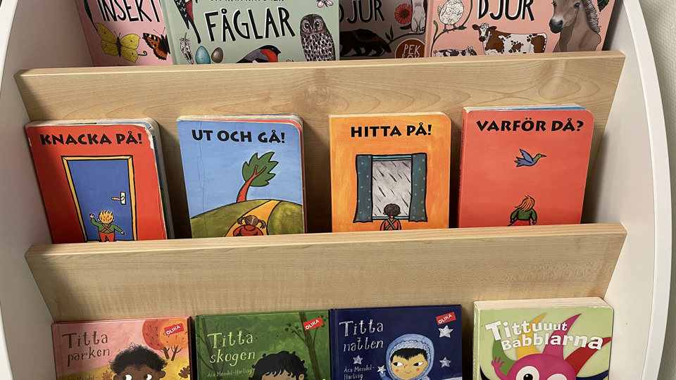 Bokhylla med färgglada barnböcker, foto.