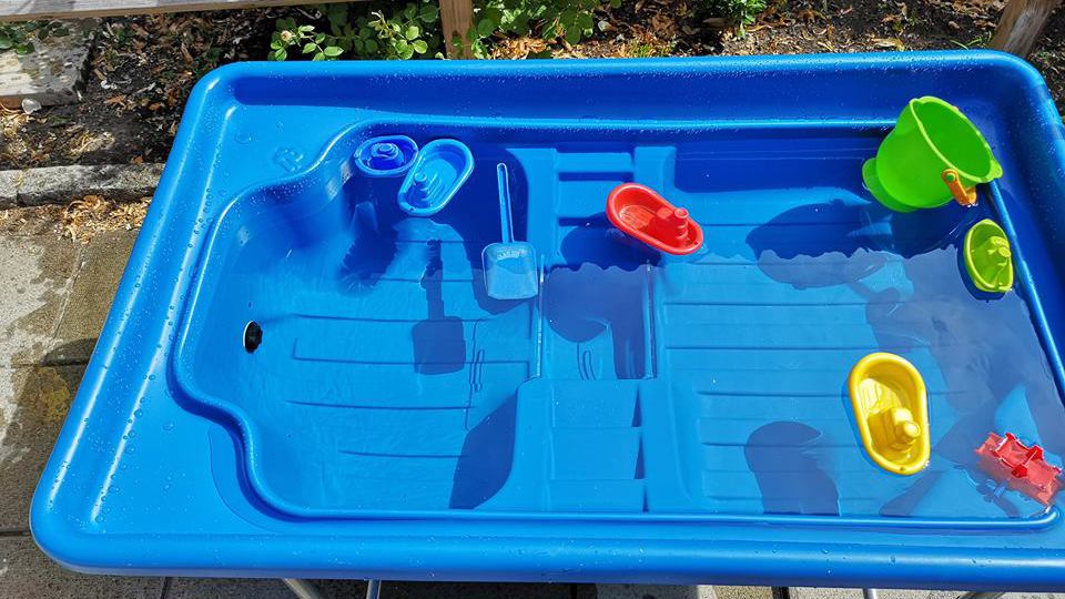 Vattenlek fylld med vatten och leksaksbåtar.