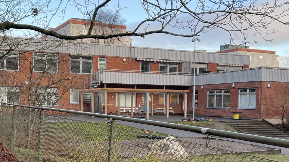 Förskolebyggnad med stor gård som är inhägnad.