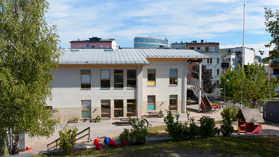 Ekbackens vitputsade förskola och lekredskap på gården.
