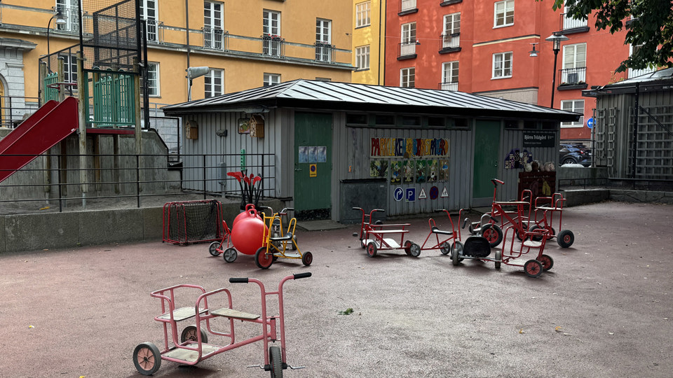 En förskolegård med många olika trehjuliga cyklar.