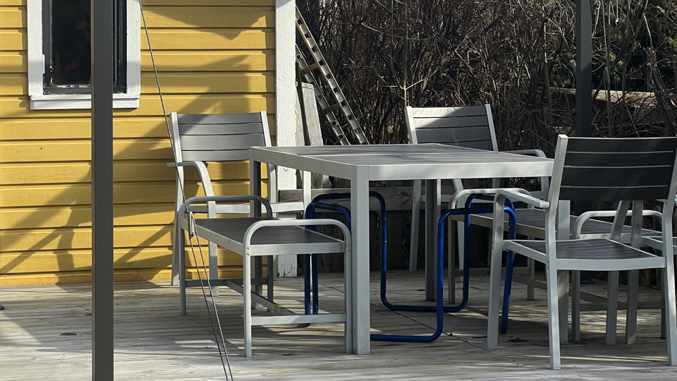 Sittgrupp utanför en gul lekstuga på Östergårdens familjehem.jpg