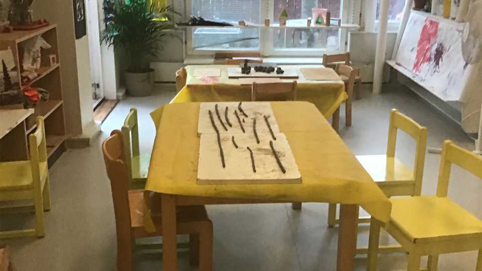 Lågt bord med pappersduk och långa lerklumpar på duken.
