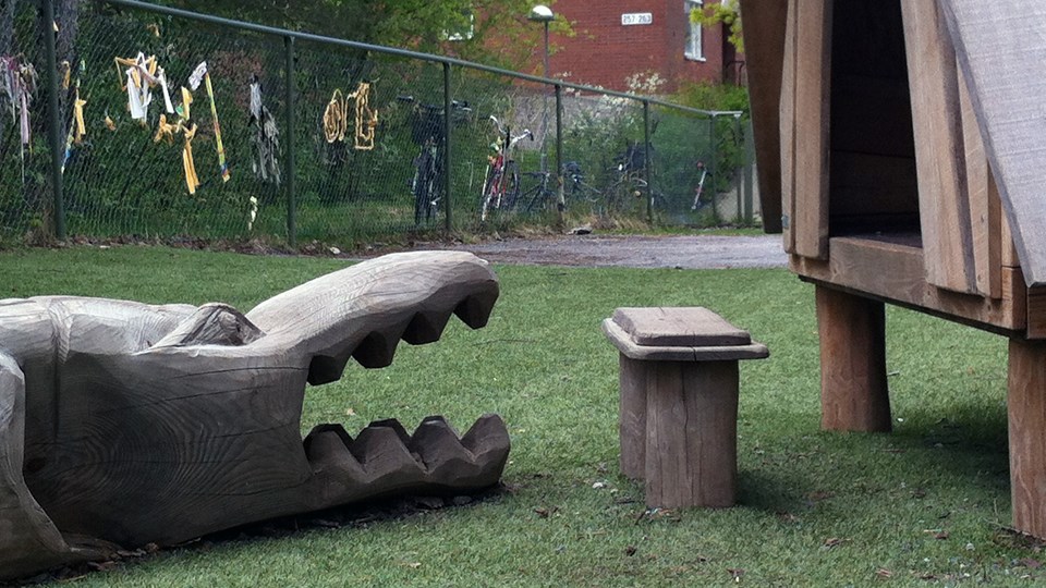 Närbild på lekredskap i trä; en krokodil och koja.
