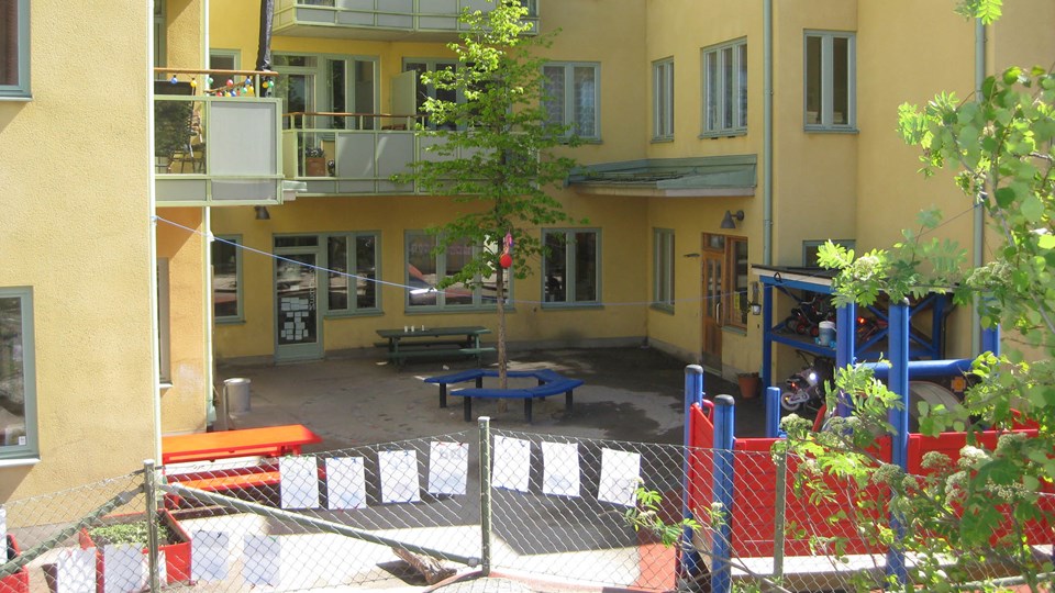 Förskolans utemiljö med lekytor, bord och klätterställning.