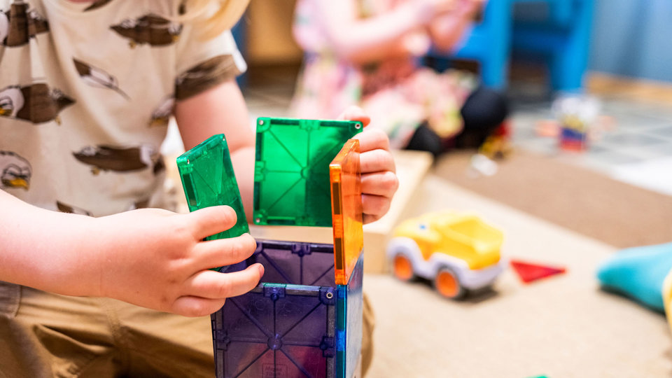 Barn som leker med färgglada leksaker i förskolemiljö. 