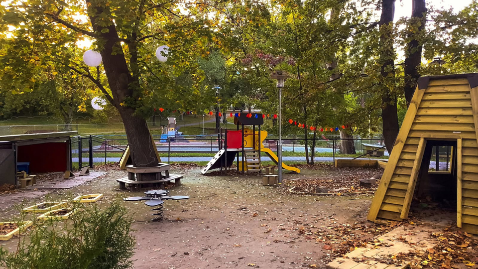 Lekpark omgiven av grönskande park.
