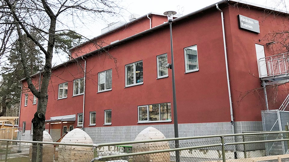 Förskolan kvarnen - en rödputsad tvåvåningsfastighet med förskolegård framför.
