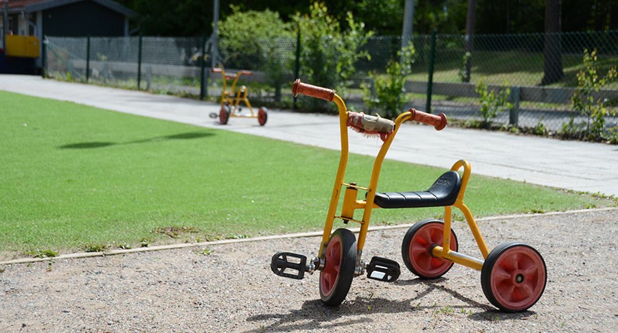 En trehjuling på förskolans utegård.