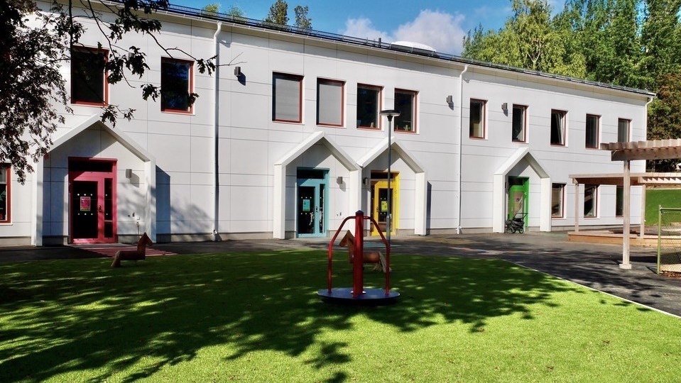 Bild på förskolan Gullängen. Ett vitt hus med färgglada dörrar.