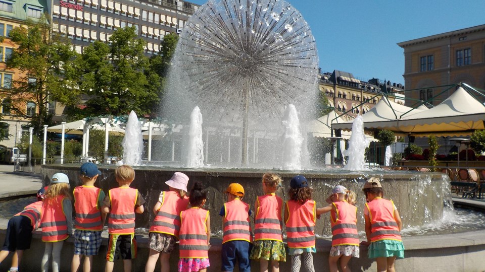 Barn ståendes vid en fontän