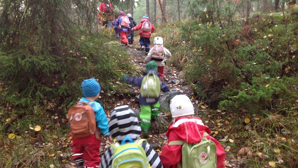 Barn med ryggsäckar på prommenad i skogen