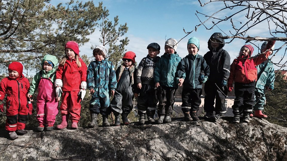 Barn i rad på ett litet berg
