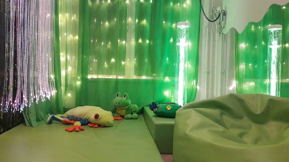 Rum med gröna mjukisdjur och textilier.